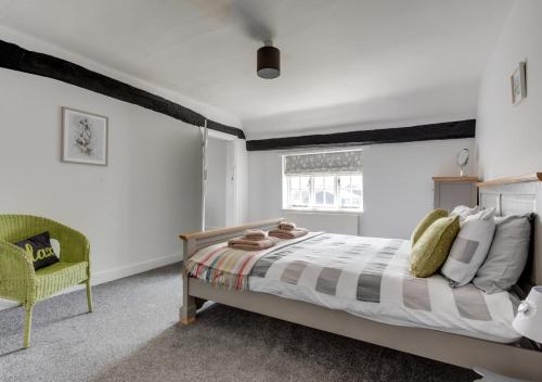 um quarto com uma cama grande e uma cadeira em The Old Hall Farm House em Reydon