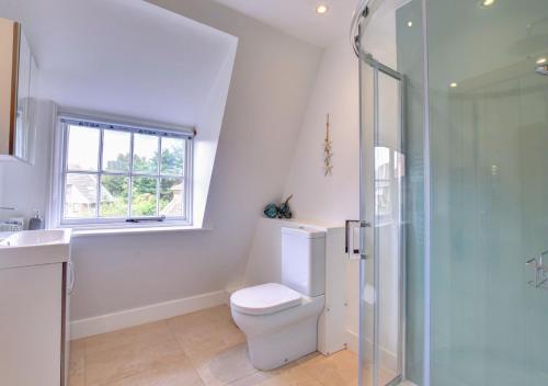 a bathroom with a toilet and a glass shower at The Lobster Pot in Orford