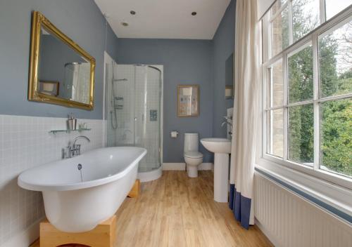 een badkamer met een bad, een toilet en een wastafel bij The Old Rectory in Haddiscoe