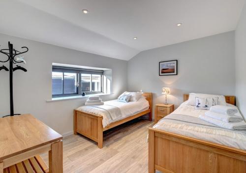 1 dormitorio con 2 camas y ventana en The Owls at Oxley en Hollesley