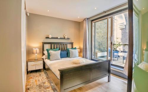 1 dormitorio con cama y ventana grande en TOWNHOUSE with ROOFTOP by Hyde Park, en Londres