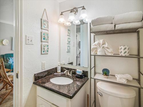 a bathroom with a sink and a toilet and a mirror at Victorian 8104-Gulf Dreams in Galveston
