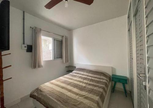 a bedroom with a bed and a ceiling fan at Ervino Praia Flat in São Francisco do Sul