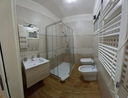 La salle de bains est pourvue d'une douche, de toilettes et d'un lavabo. dans l'établissement Villanova Apartment, à Cagliari