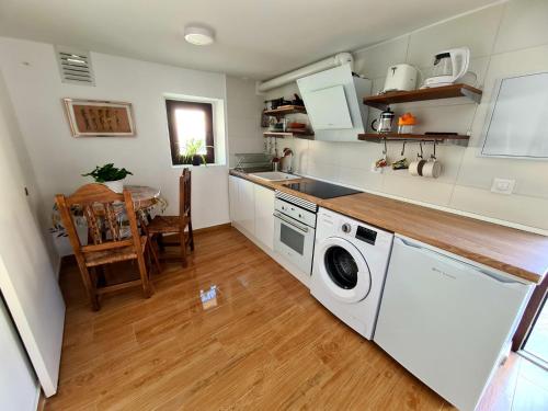 a kitchen with a washing machine and a table at Acogedora y romántica casita en la sierra in Garganta de los Montes