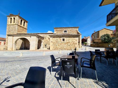 een groep tafels en stoelen voor een gebouw bij Acogedora y romántica casita en la sierra in Garganta de los Montes
