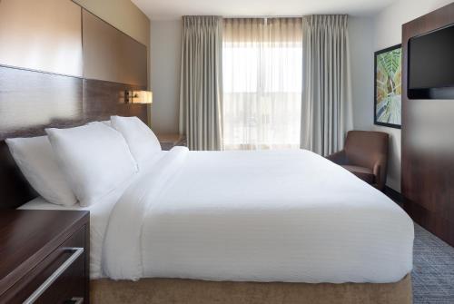 a hotel room with a large white bed and a window at Residence Inn Largo Medical Center Drive in Largo
