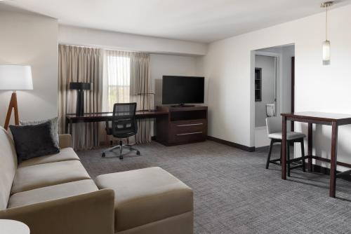 a living room with a couch and a desk with a television at Residence Inn Largo Medical Center Drive in Largo