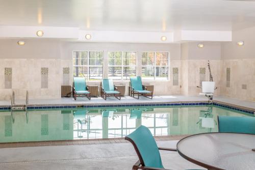 a swimming pool with blue chairs and a table at Residence Inn Largo Medical Center Drive in Largo
