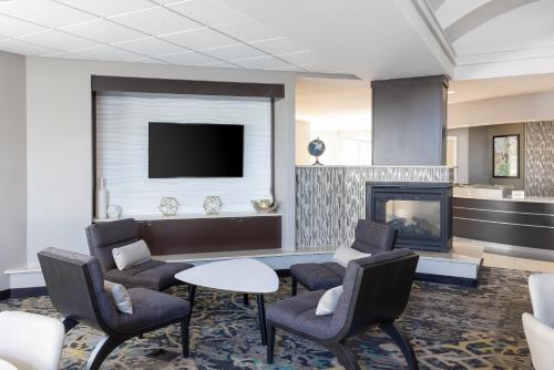 a lobby with a fireplace and chairs and a tv at Residence Inn Largo Medical Center Drive in Largo