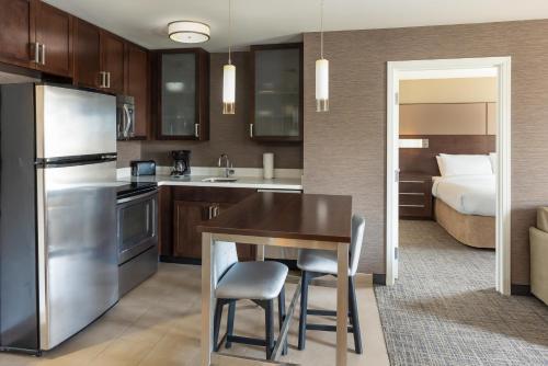 a kitchen with a table and a bed in a room at Residence Inn Largo Medical Center Drive in Largo