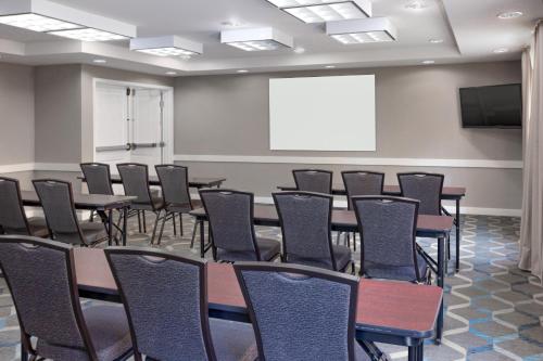 a conference room with tables and chairs and a screen at Residence Inn Largo Medical Center Drive in Largo