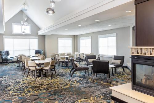 a dining room with tables and chairs and a fireplace at Residence Inn Largo Medical Center Drive in Largo