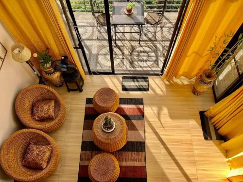Ofrece vistas panorámicas a una sala de estar con sillas y un balcón. en Dicimulacion Staycation House, en Angono