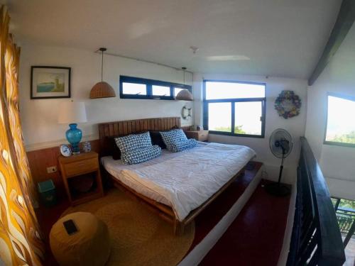 sypialnia z łóżkiem z niebieskimi poduszkami w obiekcie Dicimulacion Staycation House w mieście Angono