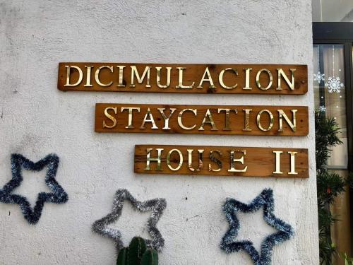 a sign on a wall with stars on it at Dicimulacion Staycation House in Angono