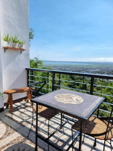 a table and chairs on a balcony with a view at Dicimulacion Staycation House in Angono