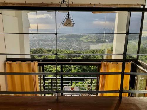 a room with a large window with yellow curtains at Dicimulacion Staycation House in Angono