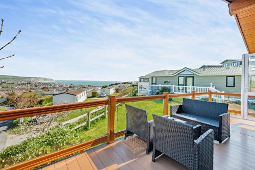 a deck with two chairs and a table on a balcony at Butterfly Lodge in Swanage