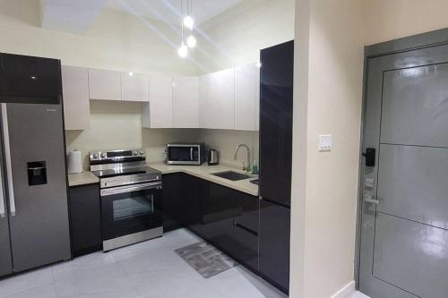 a kitchen with black and white cabinets and a microwave at Odyssey Allure in Kingston