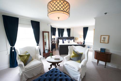a living room with white chairs and a couch at Kennebunkport Inn in Kennebunkport