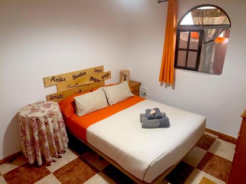 a bedroom with a bed with an orange and white sheets at Reducto's Rooms in Arrecife