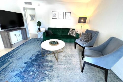 a living room with a green couch and a table at LOCATION! Apartment in Coconut Grove with parking in Miami