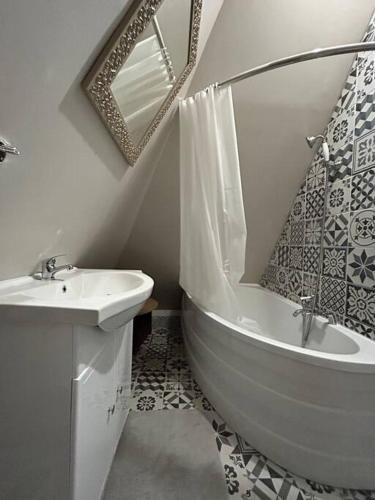 une salle de bain avec un lavabo, une baignoire et des toilettes dans l'établissement Le grenier des inities, à Manneville-la-Raoult