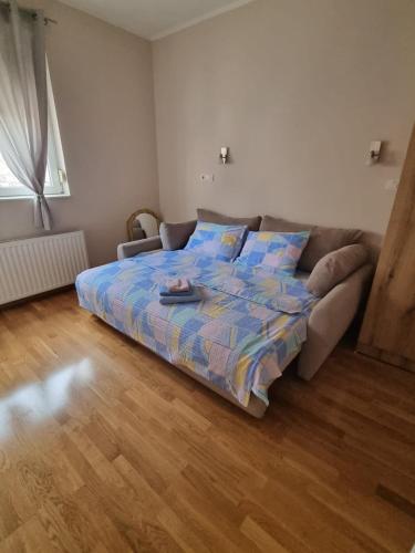 een slaapkamer met een bed en een bank bij Apartman Urošević in Osečina