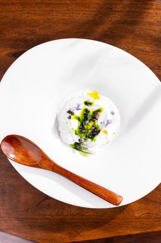 a white plate with a spoon and some food on it at The Grand Hotel in Kennebunk