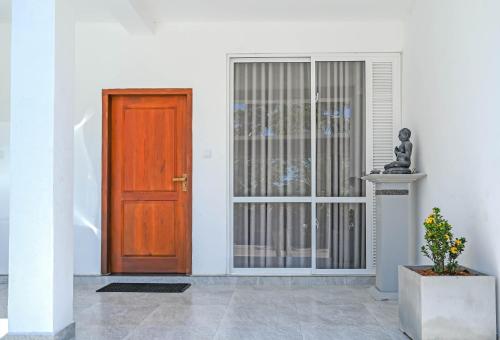 a door to a building with a statue next to it at Lake Red 6 Apartments & Hotel in Nugegoda