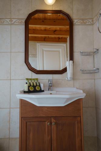 a bathroom with a sink and a mirror at Phaedra Hotel in Hydra