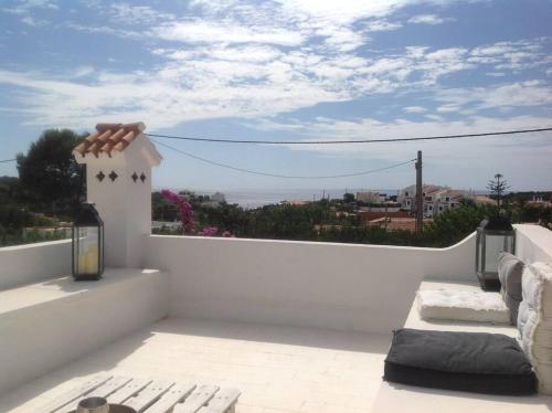 a white balcony with a view of the ocean at Private beautiful house - ( nice swimming Pool) in Cala'n Porter