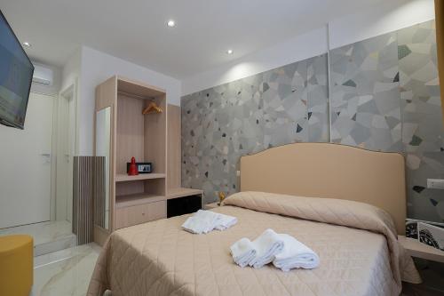 a bedroom with two towels on a bed at GreRos H. Rooms Napoli Centro by Clapa Group Dislocated Hospitality in Naples