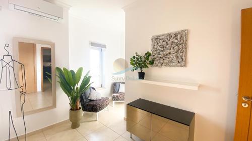 sala de estar con mesa, silla y pared en Villa Jardins 2 by Sunny Deluxe, en Albufeira