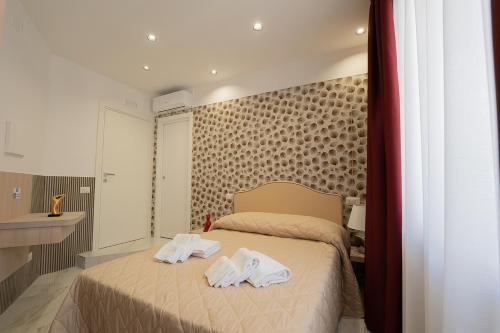 Postel nebo postele na pokoji v ubytování GreRos H. Rooms Napoli Centro by Clapa Group Dislocated Hospitality