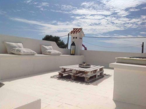 a patio with a table on a roof at Private beautiful house - ( nice swimming Pool) in Cala'n Porter