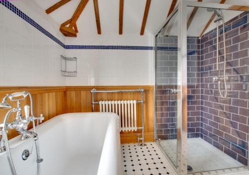 a bathroom with a tub and a glass shower at The Maltings in Southwold