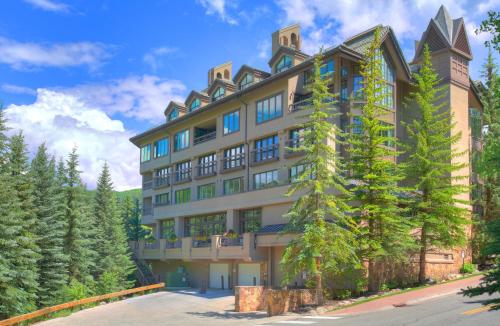 a large building with trees in front of it at The Pines Lodge, a RockResort in Beaver Creek