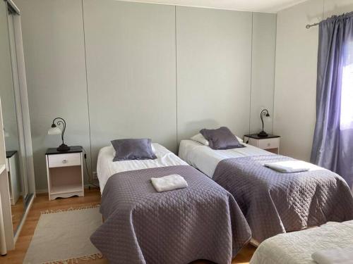 a bedroom with three beds with towels on them at huoneistomajoitus KONTU, LaatuLomat in Juva