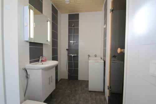 een kleine badkamer met een wastafel en een toilet bij huoneistomajoitus KONTU, LaatuLomat in Juva