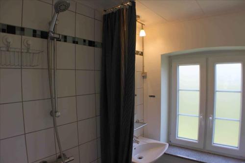 a bathroom with a shower and a sink and a window at Holmegrd - A Cozy Country House On The Outskirts Of Sby in Soby Mark