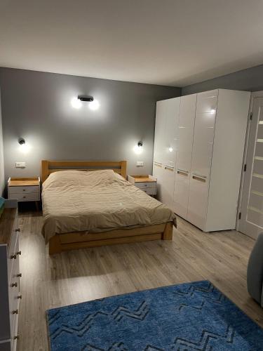 a bedroom with a bed and white cabinets and a blue rug at Hygge Apartment in Mizhhirya