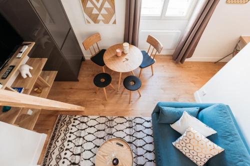 a living room with a blue couch and a table at Le petit Bancel- Jean Macé in Lyon