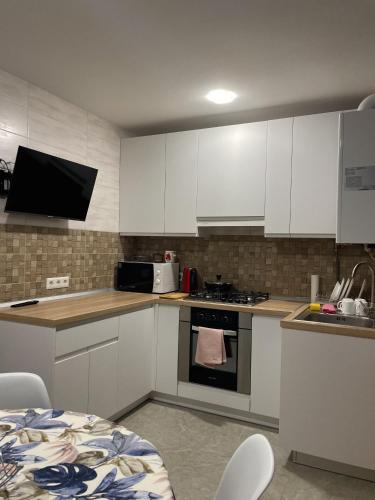 een keuken met witte kasten en een fornuis met oven bij Hygge Apartment in Mizhhirya