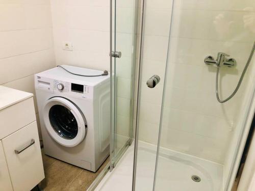 a washing machine in a bathroom with a shower at Joy City Stay Victoriei 7G-9 in Timişoara