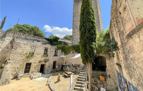 an old stone building with a tall tower and stairs at Gorgeous Home In Sommières With Wifi in Sommières