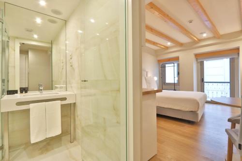 a bathroom with a shower and a sink and a bed at BOULEVARD Boutique Studios in Lisbon