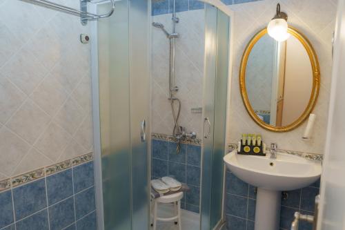 a bathroom with a sink and a shower with a mirror at Phaedra Hotel in Hydra