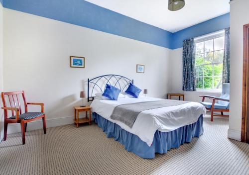 ein blau-weißes Schlafzimmer mit einem Bett und einem Fenster in der Unterkunft The Old Rectory in Tattingstone